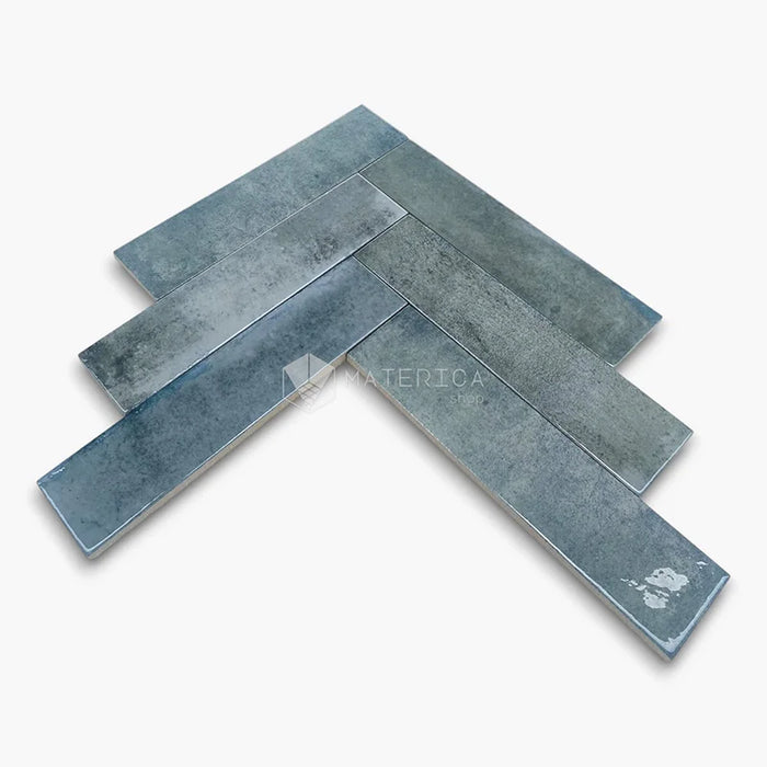 Rivestimento in gres porcellanato effetto mattoncino lucido 6x25 cm, collezione Mojave Denim di Ceramica Rondine. Piastrelle azzurre con posa a spina di pesce per pareti di bagno e cucina.