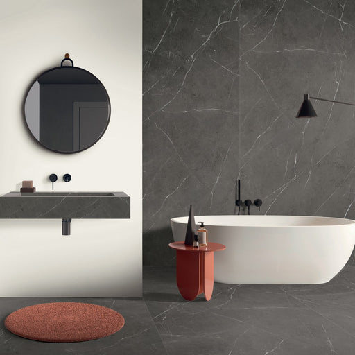 bagno moderno con vasca bianca, pavimento e rivestimento in gres porcellanato effetto marmo opaco, della collezione La Marmoteca di Gardenia Orchidea, formato 60x120 NAT. PTECH, colore Grey Stone