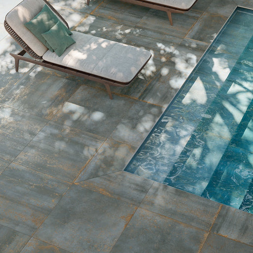 Piscina interrata con pavimento in gres porcellanato effetto metallo ossidato della collezione oxide nella colorazione green di gardenia orchidea formato 80x80