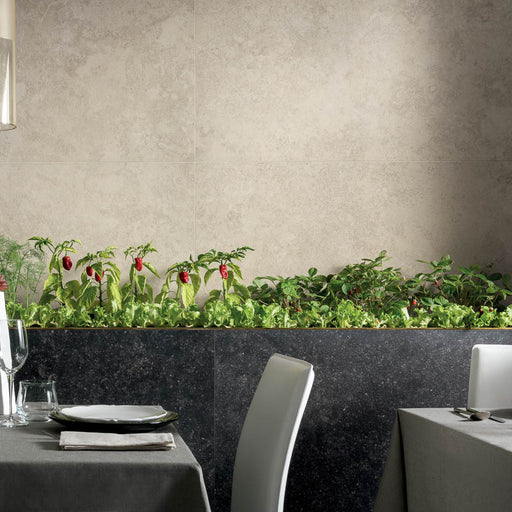 ristorante con sedie grigie e muro con rivestimento in gres porcellanato effetto pietra naturale della collezione Origini di Gardenia Orchidea, formato 60x120, colore Borgheri