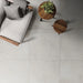 Salotto con pavimento interno in gres porcellanato effetto cemento spatolato della collezione Terre Vive di Savoia Italia, formato 90x90 cm, colore Gesso