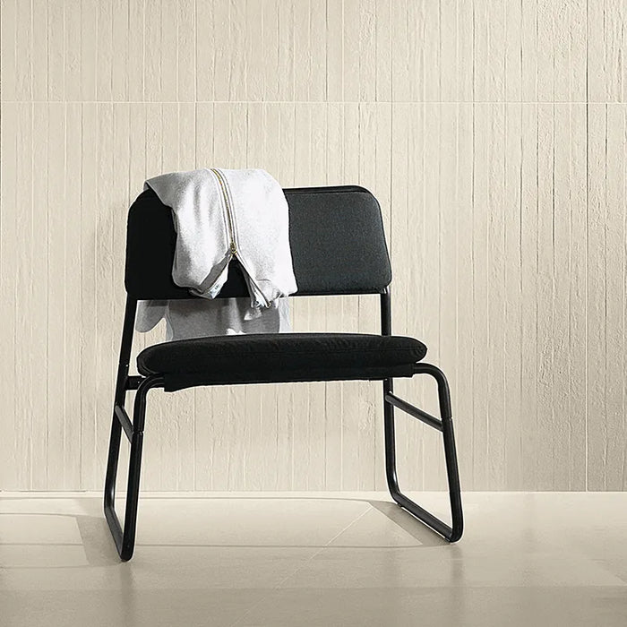 Dettaglio con sedia e rivestimento in gres porcellanato effetto cemento rigato a rilievo della collezione Riga di Settecento Ceramica, colore Cloud 90x90