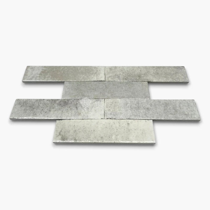 Rivestimento in gres porcellanato effetto mattoncino lucido 6x25 cm, collezione Soho Light Grey di Ceramica Rondine. Piastrelle grigio chiaro con posa a correre sfalsata per pareti di bagno e cucina.