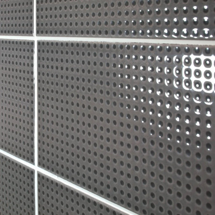 Dettaglio piastrella da rivestimento in pasta bianca effetto puntinato a rilievo della collezione Sketches di Ceramica settecento, formato 10x20 cm, colore Charcoal Dots