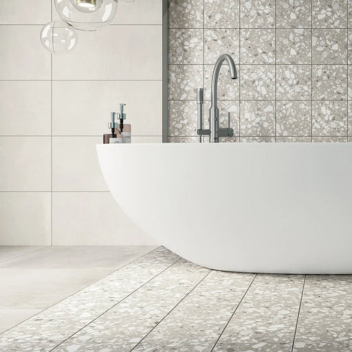 Bagno con pavimento e rivestimento in gres porcellanato effetto graniglia e marmetta. Collezione Venexia di Alfalux, formato 20x20 cm, colore Cannaregio Tortora con marmette grigie e bianche