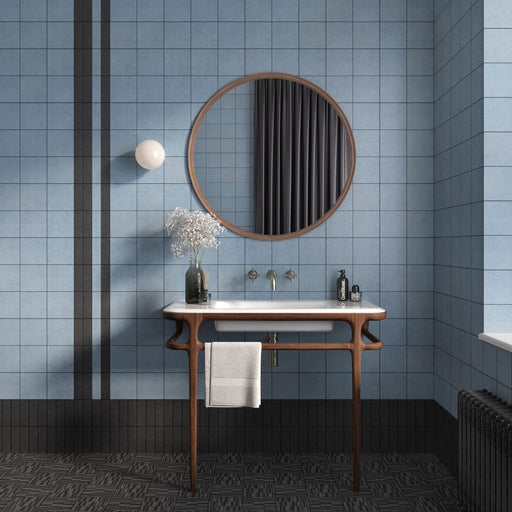 Bagno con lavabo vintage in legno e ceramica, specchio tondo e rivestimento semilucido origini in gres porcellanato smaltato nella colorazione aqua di self style by keradom.