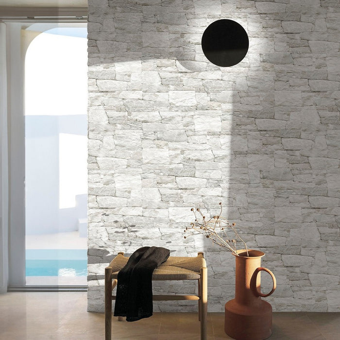 Parete di salotto interno rivestito con piastrelle effetto muretto in pietra, collezione in gres porcellanato canyon di walls and more keradom. Colore Organic