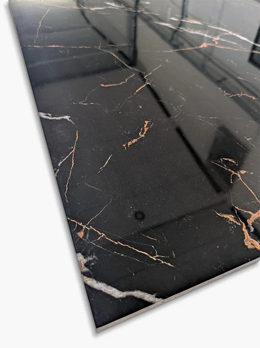 Dettaglio della superficie levigata lucida nera con venature dorate e bianche della piastrella Xstone Marquinia Gold Black