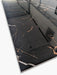 Dettaglio della superficie levigata lucida nera con venature dorate e bianche della piastrella Xstone Marquinia Gold Black