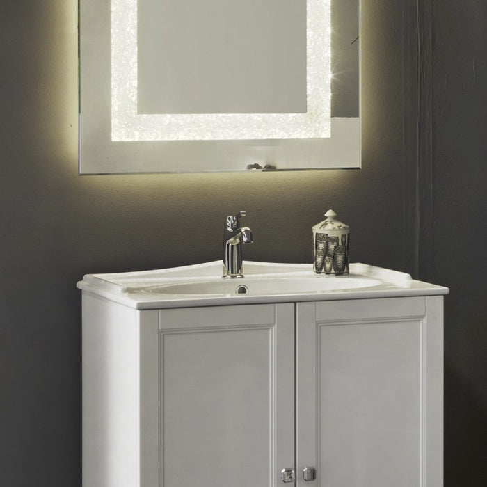 dettaglio del lavabo in ceramica lavorata in stile classico e dello specchio classico con banda luminosa abbinati al mobile bagno classico della serie Ricordi