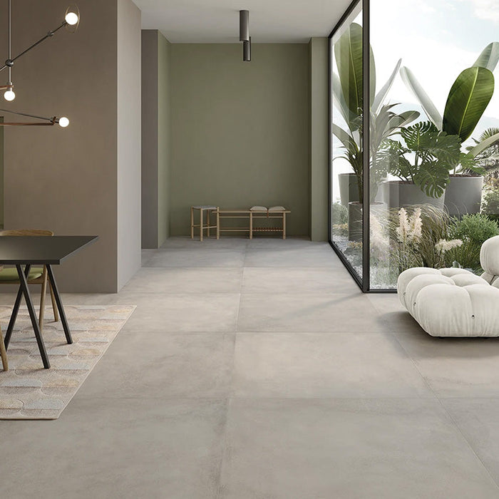 Soggiorno con pavimento in gres porcellanato effetto metallo. Plate di ceramiche keope 80x80 colore Silver