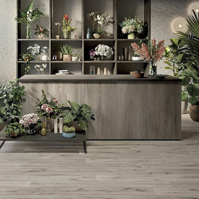 Negozio di fiori con pavimento in gres porcellanato effetto legno rovere della collezione Unica di Ceramiche Keope, formato 20x180, colore Grey