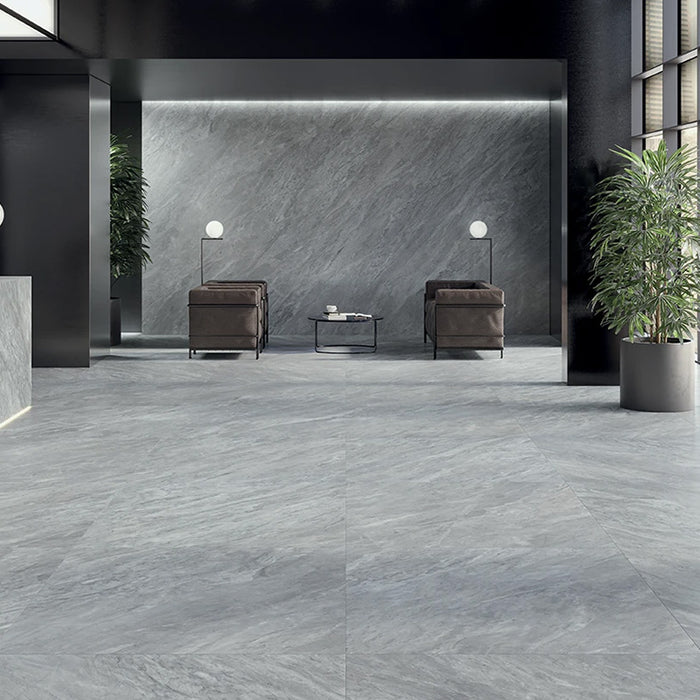 Sala d'attesa con pavimento e rivestimento in gres porcellanato effetto marmo grigio della collezione Versilia di Ceramiche Keope, formato 60x60, colore Nuvolato Grey