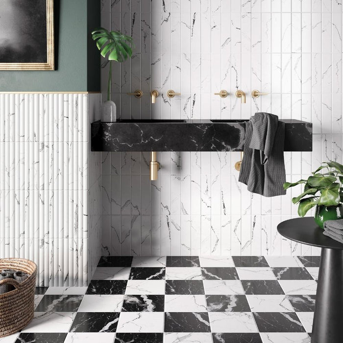 bagno con lavabo in marmo nero e rubinetti oro con rivestimento e pavimento in gres porcellanato effetto marmo opaco della collezione puro nei formati 6x25-12,5x25-25x25 nelle colorazioni Statuario e Nero Marquinia di self style by keradom