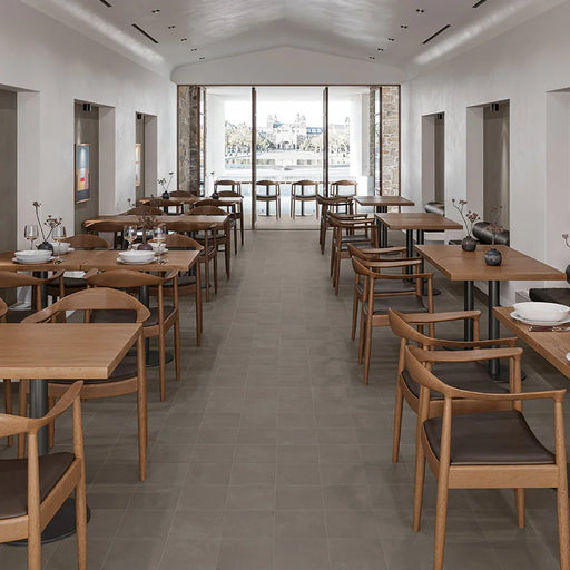 Ristorante con pavimento in gres porcellanato effetto cemento nuvolato della collezione Terrae di Casalgrande, formato 20x20 cm, colore Tabacco