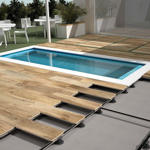 Pavimentazione di bordo piscina con gres porcellanato effetto legno spessorato 20mm. Posa su piedistalli sopraelevata. Collezione Vintage di Savoia Italia colore Miele 40x120