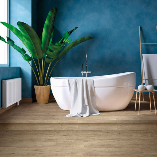 Ambiente bagno con vasca freestanding bianca e palma. Particolare del pavimento in gres porcellanato serie chalet di savoia ceramiche colore honey. formato 20x120